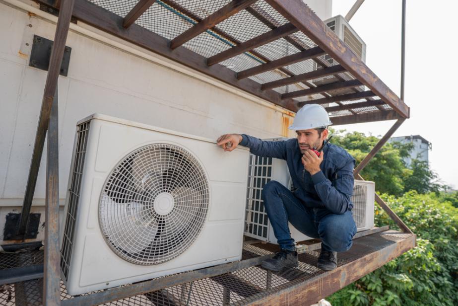 HVAC technician inspecting air conditioning unit